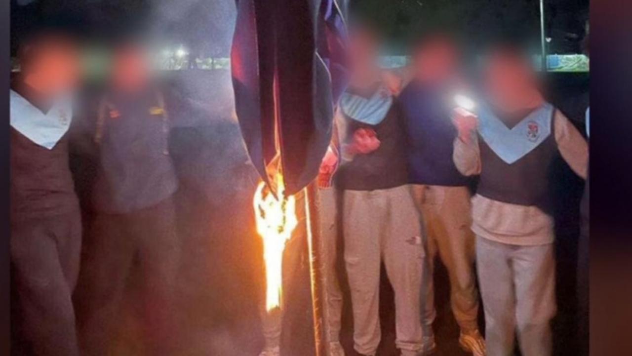 7NEWS has obtained images of a disturbing act that has plunged all-boys private school Blackfriars into crisis., Students posed for pictures as a rival college's sports jacket was set on fire., Several students have been expelled and suspended while police are now investigating Picture: 7NEWS