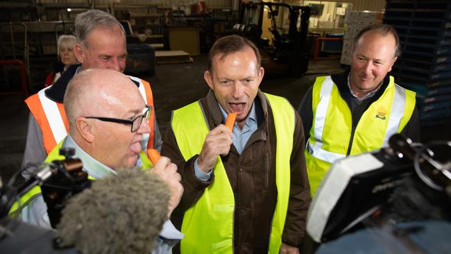 Former Prime Minister Tony Abbott and Liberal Braddon candidate Brett Whiteley, left sample a Harvest Moon carrot, to the amusement of Senator Richard Colbeck and Harvest Moon agriculture director Mark Kable, right. Picture: GREG WELLS