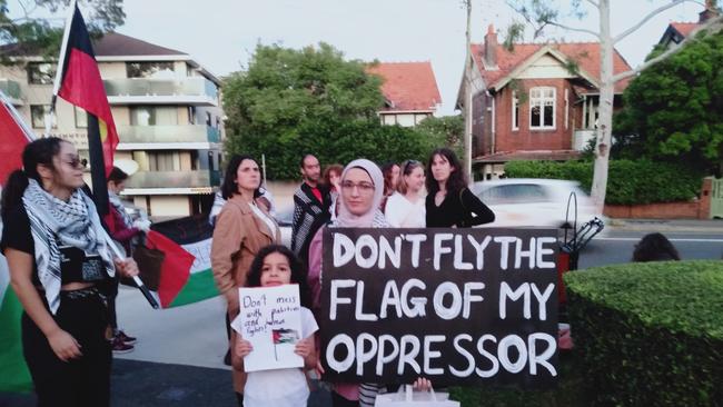 Protesters with a sign saying ‘Don’t fly the flag of my oppressor’.