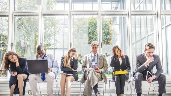 Multiracial group of business people sitting in a waiting room during company's bankruptcy – Depressed and tired team of businessmen waiting for a job interview – Concepts about business, bankruptcy, crisis and economic depression