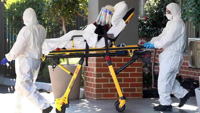 A resident of the Arcare facility in Maidstone, the epicentre of Melbourne’s aged-care outbreak, is taken to an ambulance on Monday. Picture: David Crosling