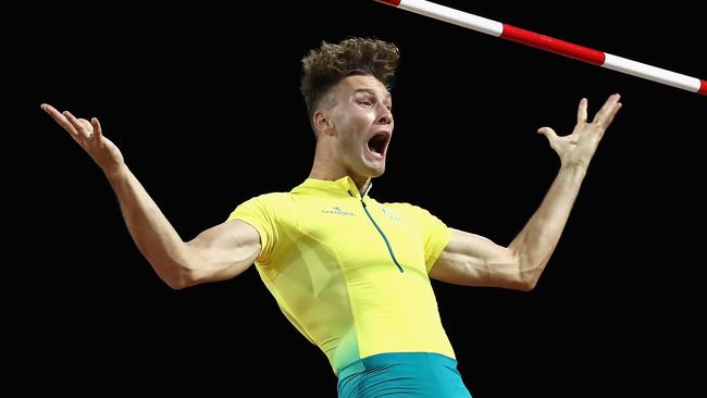 Kurtis Marschall clears the bar at 5.70m on his third attempt in the pole vault final last night, celebrating as he falls to the mat. Picture: Getty Images