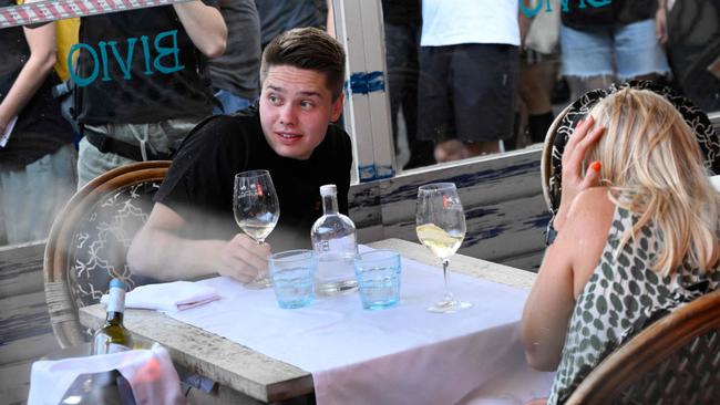 TOPSHOT - Demonstrators put symbolic cordon on a bar-restaurant window during a protest against mass tourism on Barcelona's Las Ramblas alley, on July 6, 2024. Protests against mass tourism have multiplied in recent months across Spain, the world's second-most visited country. (Photo by Josep LAGO / AFP)