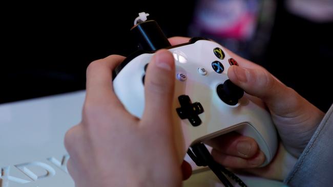 (FILES) In this file photo taken on November 5, 2017 a gamer plays video games with a Xbox console during the 2017 Paris Games Week exhibition at the Porte de Versailles exhibition centre in Paris. Video gaming can be addictive in the same way as cocaine or gambling, the World Health Organization said on June 18, 2018 in a much anticipated update of the International Classification of Diseases (ICD-11). / AFP PHOTO / Thomas SAMSON