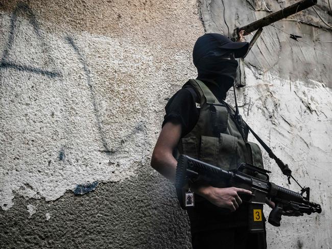 A masked Islamic Jihad fighter stands in an alley at the Jenin camp in the West Bank on November 4, 2023, as violence surges in the occupied territory amid the ongoing battles between Israel and the Palestinian group Hamas in the Gaza Strip. Picture: AFP.