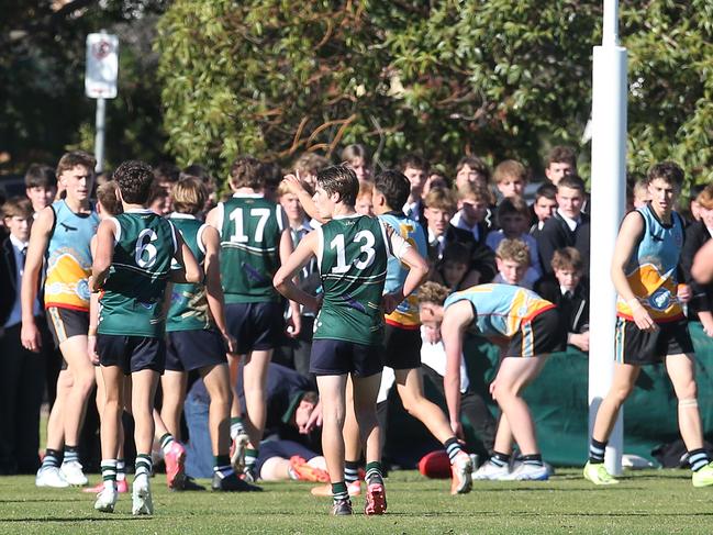 Players and officials converge around an injured Geelong College player who collided with a goalpost. An ambulance was called and he was stretchered off. Geelong College v Geelong Grammar boys. Picture: Alan Barber