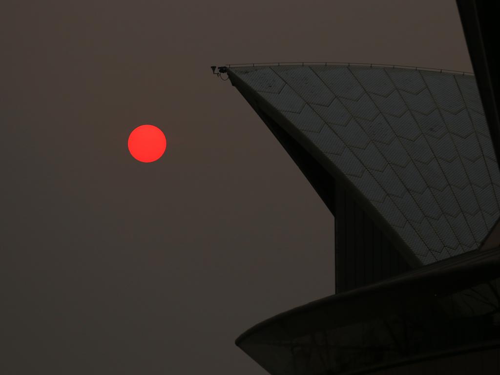 The sun is seen through bushfire haze next to the Sydney Opera House during hot weather in Sydney, Thursday, December 19, 2019. Picture: Steven Saphore/AAP