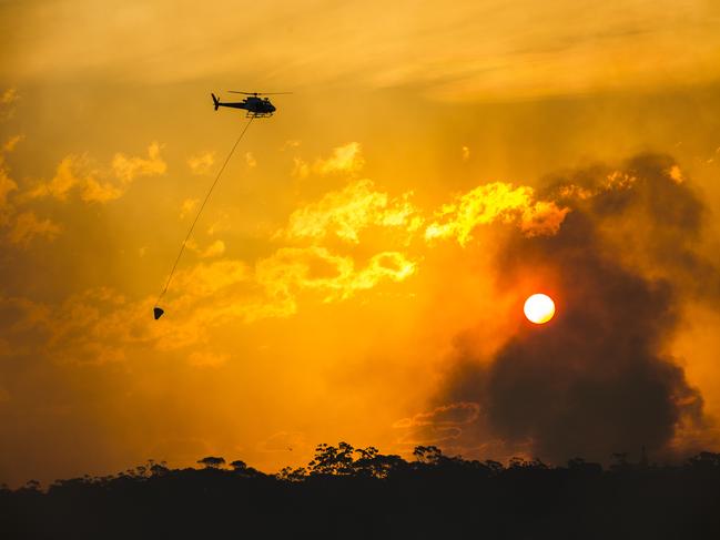 Helicopters water bomb a bush fire at Alfords Point and Menai on Sunday afternoon. Picture: Damian Shaw