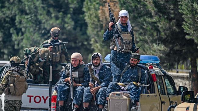 Taliban fighters patrol along a street in Kabul.