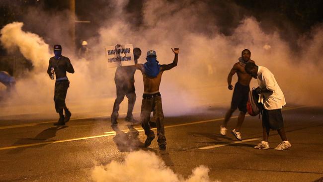 People protest as tear gas canisters detonate around them on Wednesday. AP Photo/St. Louis Post-Dispatch, Chris Lee