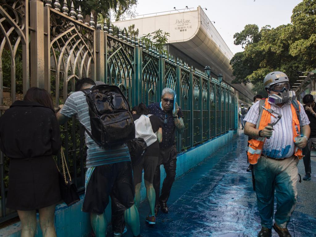 People sprayed with blue-dyed water by a police riot-control vehicle during a protest outside the Kowloon Mosque in Hong Kong. Picture: AP