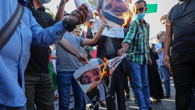 Protesters burn pictures of Mohammed bin Zayed Al-Nahyan in Ramallah on Saturday. Picture: AFP