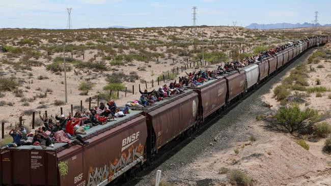 Migrants of various nationalities seeking asylum in the United States ride atop freight cars of “The Beast” train as they arrive in the border city of Ciudad Juarez. Picture: Herika Martinez/AFP