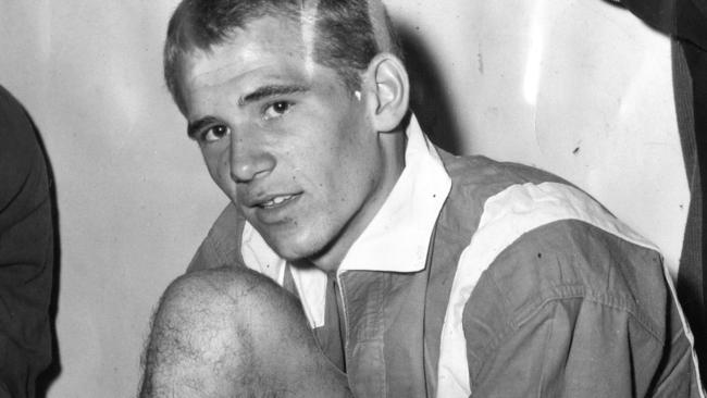 Steve Herczeg laces up his boots before soccer training in 1962.