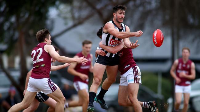 Jonathan Giannini of Payneham Norwood Union gets a handball away for the Falcons during a match at Payneham Oval in August. Picture: Kelly Barnes