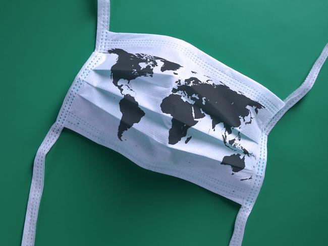 White face mask with a map of the world is lying on a blue background.