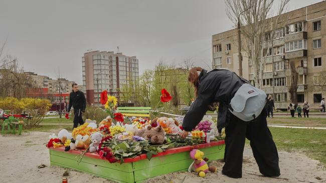 Flowers and toys left in the play area to commemorate victims killed in Russia's missile attack on Friday, near apartment buildings Ukraine on Saturday. Picture: AP