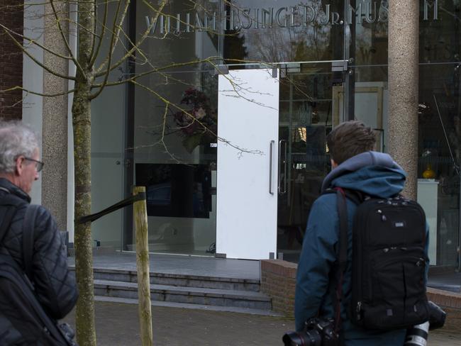 Journalists look at the damaged glass door of the Singer Museum in Laren, Netherlands. Picture: AP