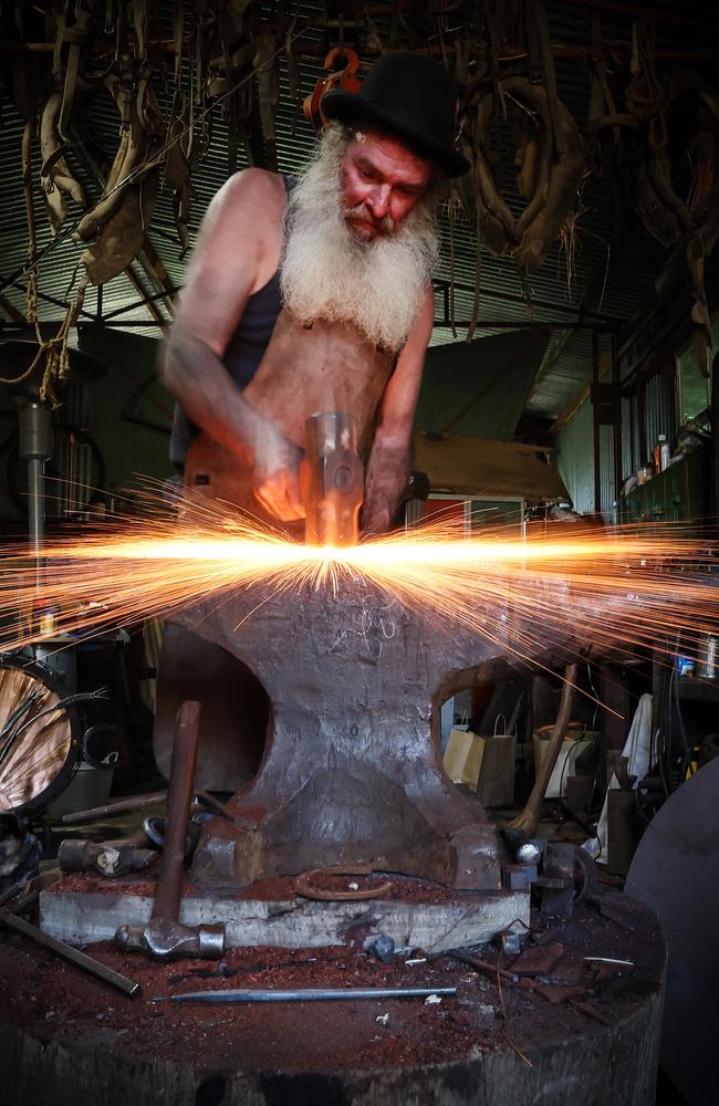 Brendan Thompson mid-hammer in his King Valley workshop. Picture: David Caird