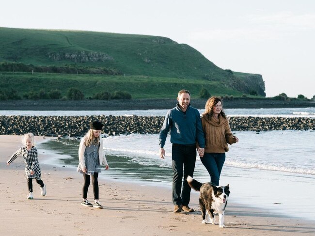 Owners of the Ship Inn Alastair and Kerry Houston, walking their border collie Floss, on Godfrey's Beach, at Stanley, with their daughters Lucy and Bonnie. Picture: Supplied.