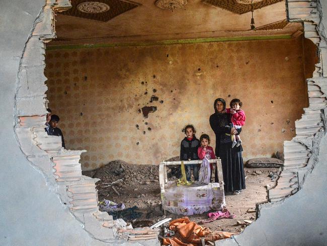 A women and her children stand in the ruins of battle-damaged house in the Kurdish town of Silopi, in southeastern Turkey, near the border with Iraq on January 19, 2016. Picture: AFP PHOTO / ILYAS AKENGIN