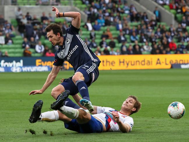 Robbie Kruse of Melbourne Victory is challenged by Lachlan Jackson of Newcastle Jets. Picture: AAP Image/George Salpigtidis