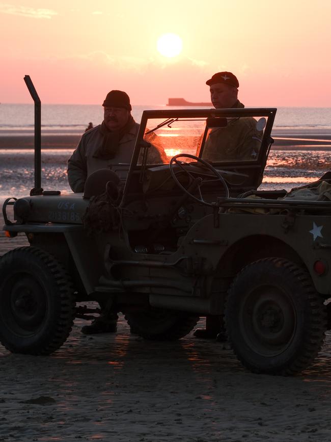 Military veterans and their WWII jeep wait for a landing craft at dawn on Arromanches-les-bains. Picture: Jacquelin Magnay