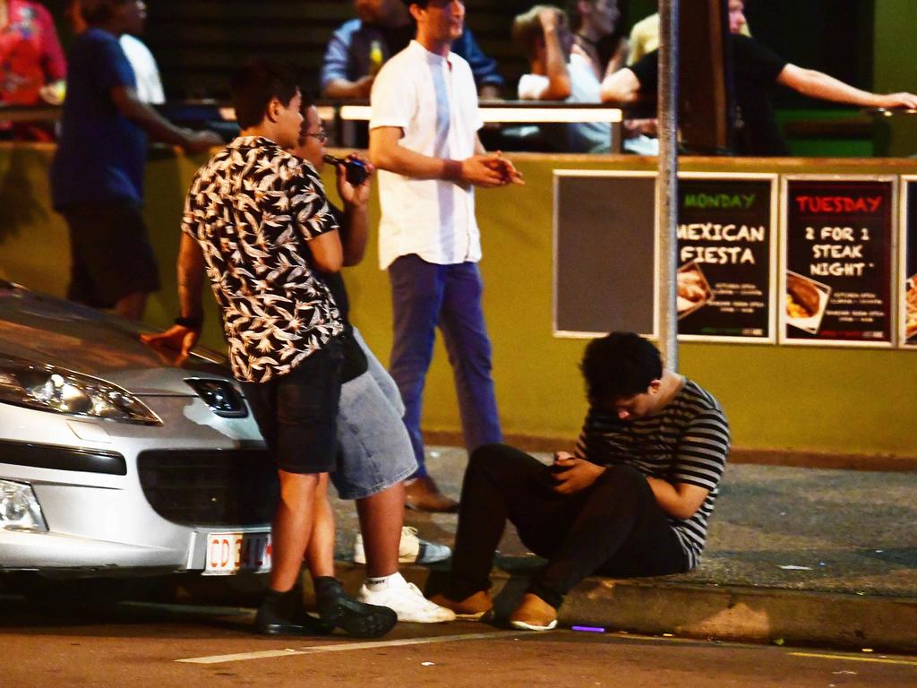 GOING: A young New Year's Eve reveller loses his balance and falls to the ground as his mates look on in the early hours of New Year's day. Pictures: Justin Kennedy