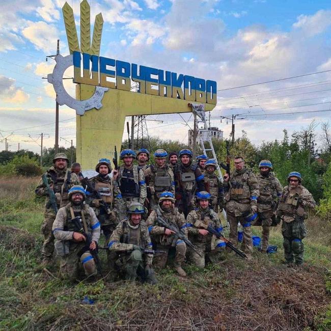 Ukrainian service members pose in the recently liberated settlement of Vasylenkove in the Kharkiv region.