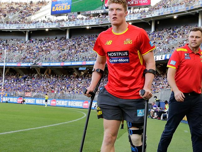 PERTH, AUSTRALIA - MARCH 21: Matt Rowell of the Suns walks back onto the ground on crutches during the 2021 AFL Round 01 match between the West Coast Eagles and the Gold Coast Suns at Optus Stadium on March 21, 2021 in Perth, Australia. (Photo by Will Russell/AFL Photos via Getty Images)