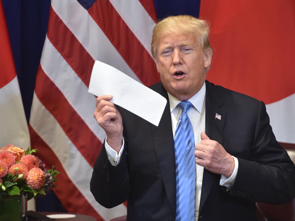 Donald Trump with one of the “beautiful letters” he received from Kim Jong-un. Picture: AFP