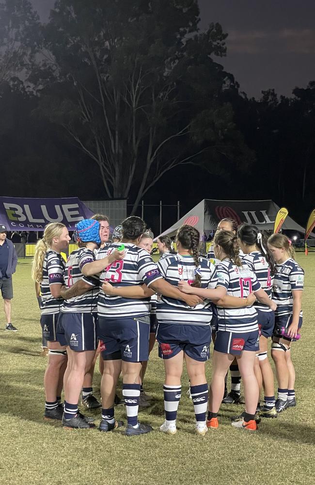 The Brothers premier grade women team in a huddle at half time.