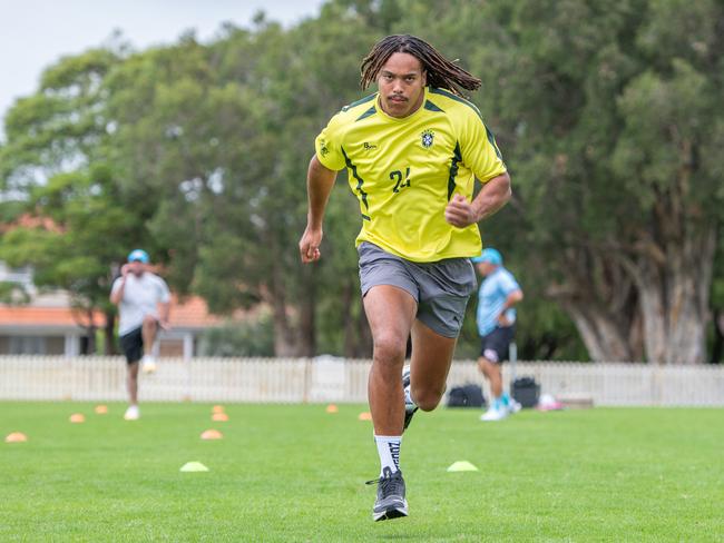 Dominic Young stretches out during a sprint training session with coach Roger Fabri. Picture Thomas Lisson