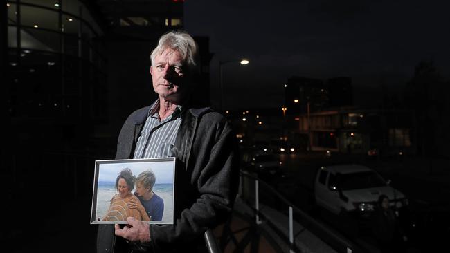 Ted Mead outside Hobart's Magistrates Court on the first day of the inquest into his son Liam’s death, holding a picture of Liam and his mother, Juliet Lavers. Picture: LUKE BOWDEN