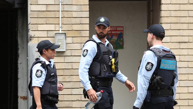 AFP officers guard the rear doors of the CFMEU building in Bulwara Road, Pyrmont. Picture: John Grainger