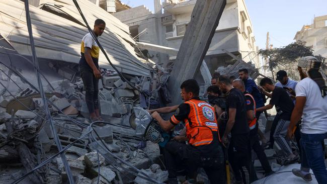 Rescuers use a wheel saw to recover people from under the rubble of a collapsed building following an Israeli air strike on Rafah in southern Gaza Strip on October 26. Picture: AFP