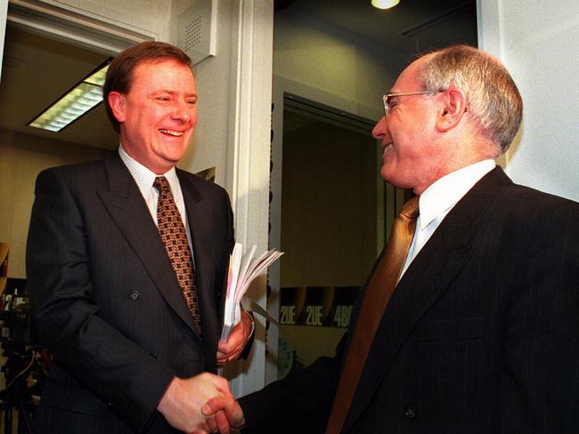 Aust politician Prime Minister John Howard (r) shaking hands with Treasurer Peter Costello while promoting GST tax package 14 Aug 1998.