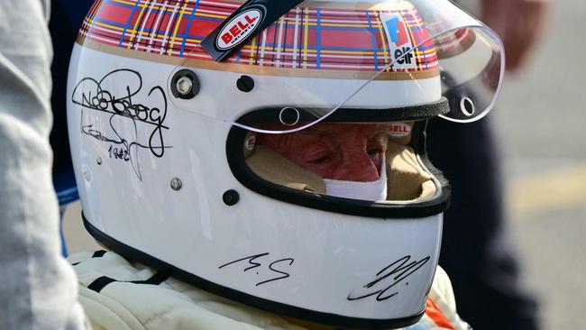 The initials ‘M.S.’ can clearly be seen among the signature on Jackie Stewart’s helmet. (Photo by Giuseppe CACACE / AFP)