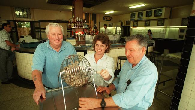 Lulla Wilson, Jenny Cavill (Patron) and Eric Nicholls (foundation member), draw another raffle for their cricket club at the Breakfast Creek Hotel in 1996.