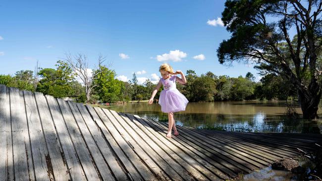 Olesia French, 4, explores her backyard in Londonderry after flood waters damaged her family's back fence and took many of her toys across the creek. Picture: Tom Parrish