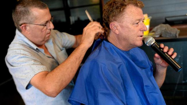 Mark West gives Peter Lynch's mullet the chop to raise funds for a sick child. Picture: Jann Houley