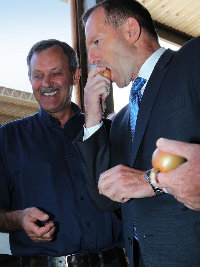 Tony Abbott samples an onion.