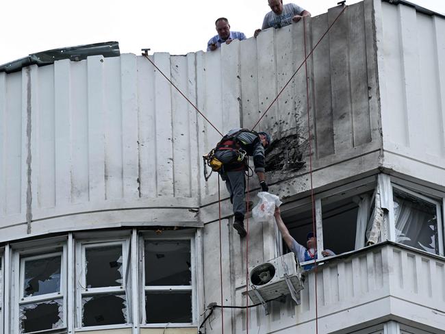 A specialist inspects the damaged facade of a multi-storey apartment building after a reported drone attack in Moscow on May 30, 2023. (Photo by Kirill KUDRYAVTSEV / AFP)