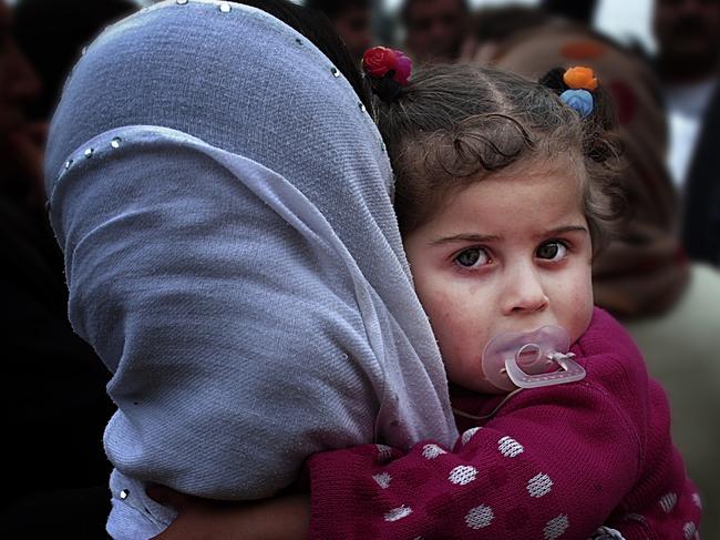 A Syrian mother and child wait to collect food from the UNHCR in northern Iraq where thousands of refugees have fled to seek refuge against Islamic State militants. The group has killed more Muslims then any other group to date.Picture: Hermoine Macura