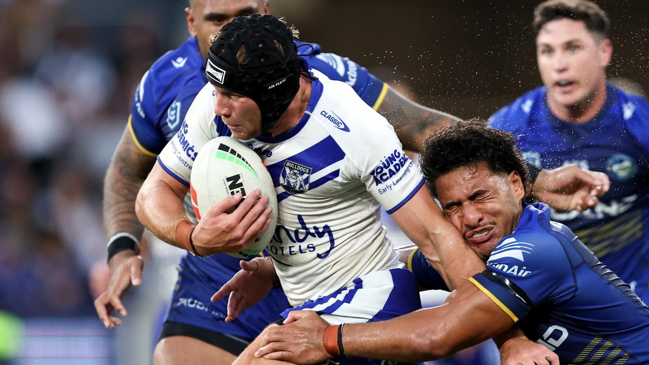 SYDNEY, AUSTRALIA - MARCH 09: Matt Burton of the Bulldogs is tackled by the Eels defence during the round one NRL match between Parramatta Eels and Canterbury Bulldogs at CommBank Stadium, on March 09, 2024, in Sydney, Australia. (Photo by Brendon Thorne/Getty Images)