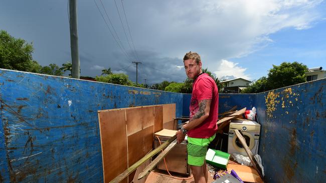 Flooding in Laura Court, Deeragun. David Greenway puts water damaged items into a skip, from his mate's house, Daniel Hanran. Picture: Evan Morgan