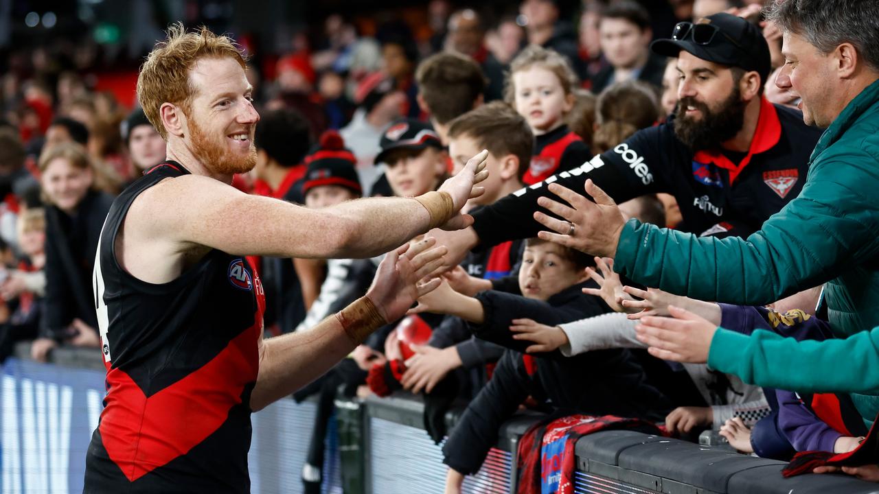 Bomber Andrew Phillips celebrates the win over North Melbourne with fans. Picture: Michael Willson