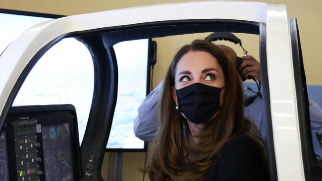 Britain's Catherine, Duchess of Cambridge, wearing black as a mark of respect following the death of Britain's Prince Philip, Duke of Edinburgh, and a face covering to combat the spread of Covid-19, sits in a flight simulator during their visit to 282 (East Ham) Squadron Air Training Corps in east London on April 21, 2021. - During the visit, the Squadron paid tribute to The Duke of Edinburgh, who served as Air Commodore-in-Chief of the Air Training Corps for 63 years. In 2015, The Duke passed the military patronage to The Duchess of Cambridge who became Honorary Air Commandant. (Photo by Ian Vogler / POOL / AFP)