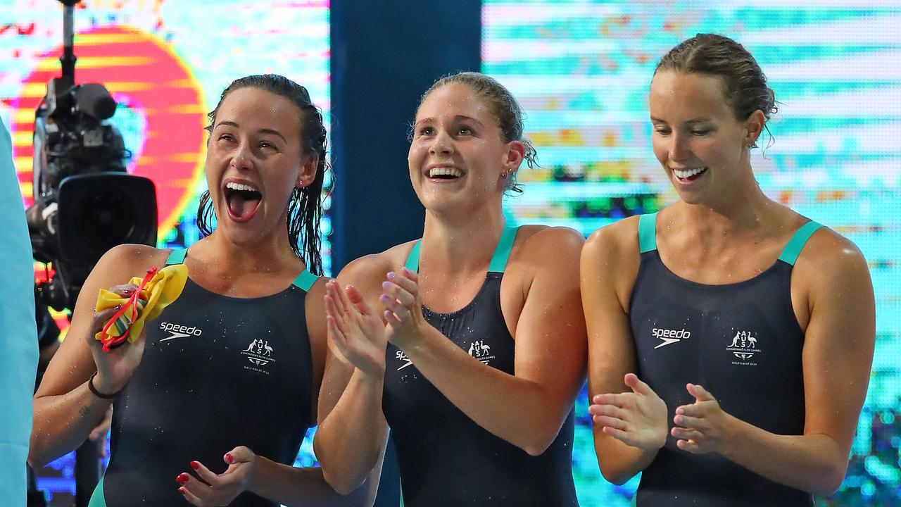 Brianna Throssell, Leah Neale and Emma McKeon cheer on Ariarne Titmus in the final of the 200m freestyle relay.