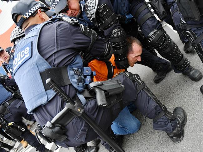 Police subdue a man after warring factions got physical. Picture: Jake Nowakowski